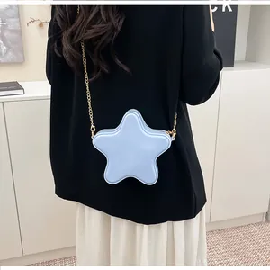 Détail du sac bandoulière bleu clair en forme d'étoile avec chaîne dorée sur mannequin