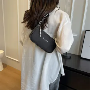 Minimalist black nylon shoulder bag with silver chain strap and Riaa & Luxury logo print