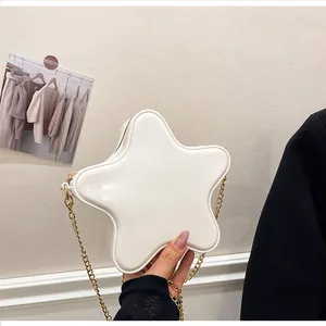 Détail du sac bandoulière blanc en forme d'étoile avec finition brillante et chaîne dorée