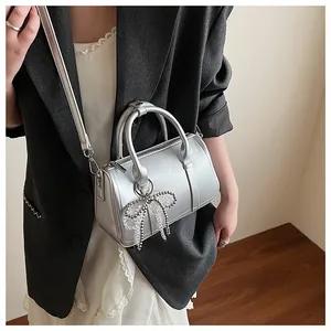 Detailansicht der silbernen Boston Bag mit Strass-Schleife und metallischer Lederstruktur