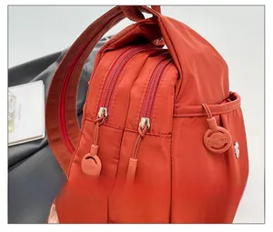 Detail shot of the orange canvas backpack with smooth double zippers and rubber pull tabs