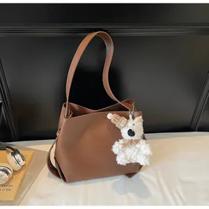 Brown PU leather bucket bag with cute plush bear charm and minimalist shoulder strap