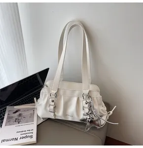 Detail of white pleated hobo bag with silver star charm and glossy finish texture