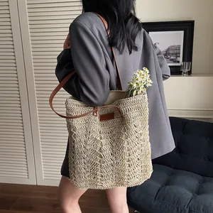 Handwoven straw tote bag with brown leather straps and YELIYA logo for beach vacations