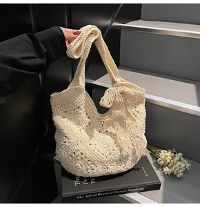 Detailed close-up of a cream crochet woven tote bag featuring a large decorative side bow