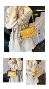 Gros plan du sac à bandoulière jaune vif avec broderie papillon blanc et détail de noeud