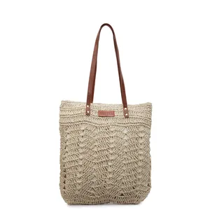 Handmade woven straw tote bag with brown leather handles for summer beach vacations