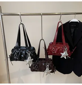 Detail of glossy pleated PU leather bag with shiny silver star pendant accessory