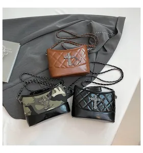 Tres elegantes bolsos con cadena en marrón, camuflaje y negro con dijes de cruz