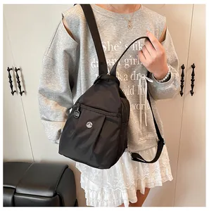 Detailed view of lightweight black nylon mini backpack worn by a model in casual setting