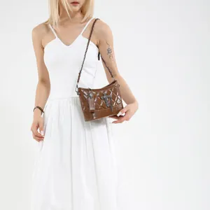 Bolso de hombro acolchado de cuero marrón con colgante de cruz y detalle de cadena