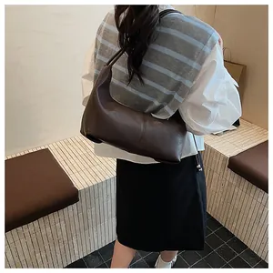 Detail showing the vertical middle seam and matte texture of the dark brown hobo bag