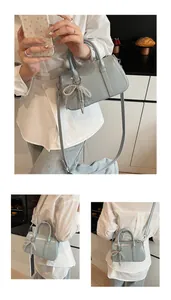 Details der hellblauen Boston-Tasche mit silbernem Schleifenanhänger und Trageriemen