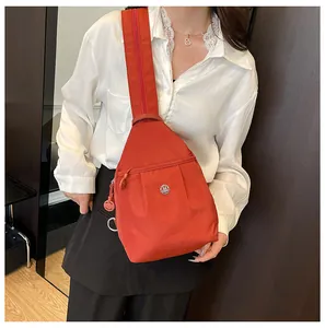 Close-up of red nylon crossbody bag featuring pleated design and round metal logo detail
