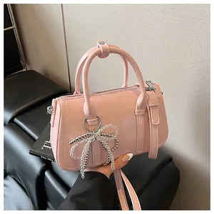 Detailaufnahme der rosa Boston-Tasche mit handgefertigtem Perlen-Schleifenanhänger