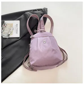Close-up of light purple nylon mini backpack with ruched texture and metal logo plate