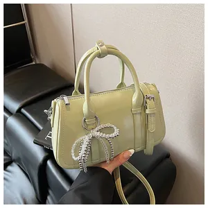 Detail der pistaziengrünen Boston Tasche mit Hochglanz-Finish und Perlen-Anhänger