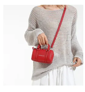 Close-up of red lychee leather mini Boston bag with silver metal hardware and logo