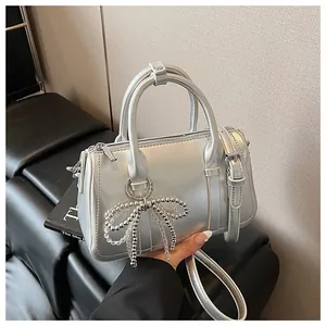 Details der silbernen Boston-Handtasche mit Perlen-Schleifenanhänger und Metallic-Finish