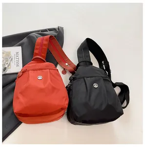 Detail of nylon crossbody chest bags in orange and black with pleated design and M logo