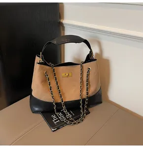 Detail of quilted leather tote featuring metal chain strap and turn-lock closure