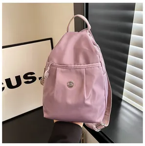 Close-up of purple lightweight nylon backpack with pleated design and metal logo detail
