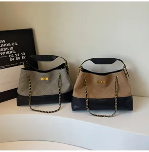 Close-up of contrast tote bags with diamond stitching, chain handles, and gold twist locks