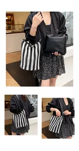 Detalle de bolso saco de punto a rayas con asa de cuero y bolsa interior negra