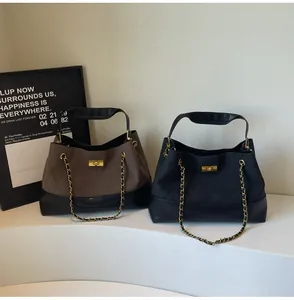 Detail of quilted tote bags with gold turn-lock closures and metal chain straps