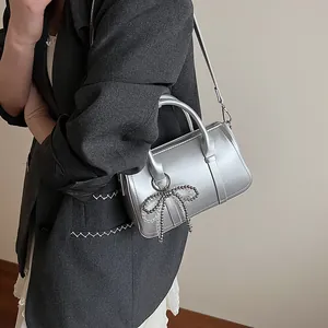Silberne Boston-Tasche mit Schleifenanhänger und Schultergurt für Damen im Sommer 2025