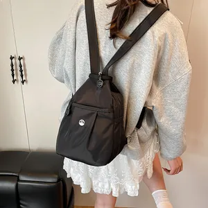Lightweight black nylon mini backpack for women featuring a pleated front and metal M logo