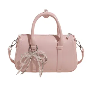 Rosa glänzende Boston-Tasche aus Lackleder mit Schleifenanhänger und Schultergurt