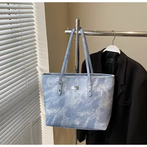 Detailed texture of light blue snowflake wash tote bag with metallic logo and rivets