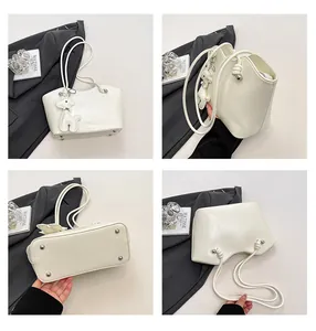 Detailsicht einer weißen PU-Leder-Einkaufstasche mit Nieten und Schaf-Anhänger-Dekor