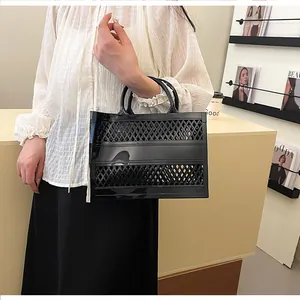 Detail of black hollowed-out jelly tote bag with woven lattice texture and flat handles