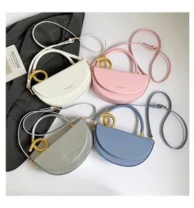 Flat lay of four leather saddle bags in white pink silver and blue with gold ring handles