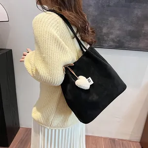 Vintage black suede tote bag with heart charm shown on a casual female model outfit