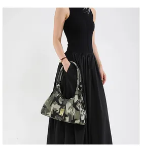 Detail of vintage camouflage underarm bag featuring a crescent shape and gold metal buckle