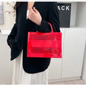 Detail of red hollowed-out PVC jelly basket bag featuring lattice patterns and top handles