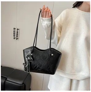Detail der schwarzen Tote Bag aus Kunstleder mit Wellenrand und Giraffenanhänger