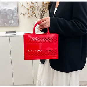 Detail of red hollow tote bag featuring diamond lattice pattern and integrated handle