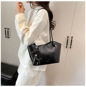 Nahaufnahme der schwarzen Ölwachs-Tote-Bag mit Hirsch-Anhänger und schmalen Riemen