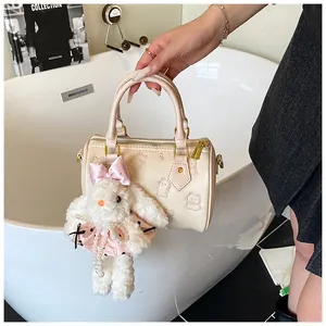 Detail of cream white printed Boston bag featuring cute embossed cat and rabbit charms
