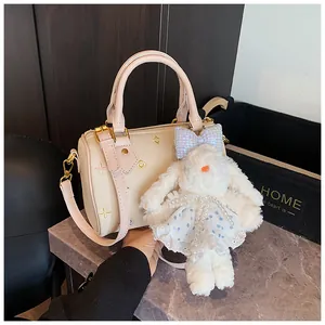 Detail of Boston bag featuring floral embroidery and a plush bunny charm on white leather