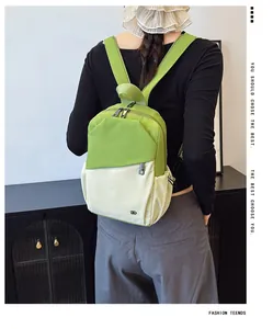 Detalle de mochila de nailon verde y beige con cremalleras dobles y bolsillos