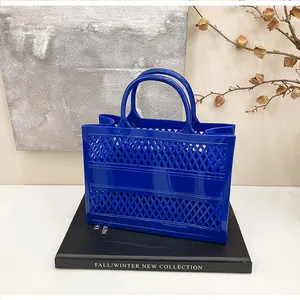 Detail of blue hollow-out jelly tote bag with rhombus lattice texture and fixed handles