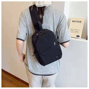 Vista trasera de un bolso bandolera multifuncional de nailon negro en una modelo