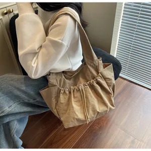 Seitenansicht khakifarbene Nylon-Stofftasche mit Falten, Kordelzug und Seitentaschen