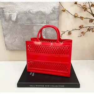 Detail shot of a vibrant red hollow-out jelly basket bag with diamond grid pattern