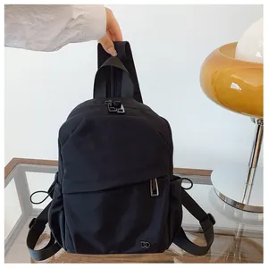 Primer plano de mochila negra multifuncional con detalle de cremallera diagonal moderna